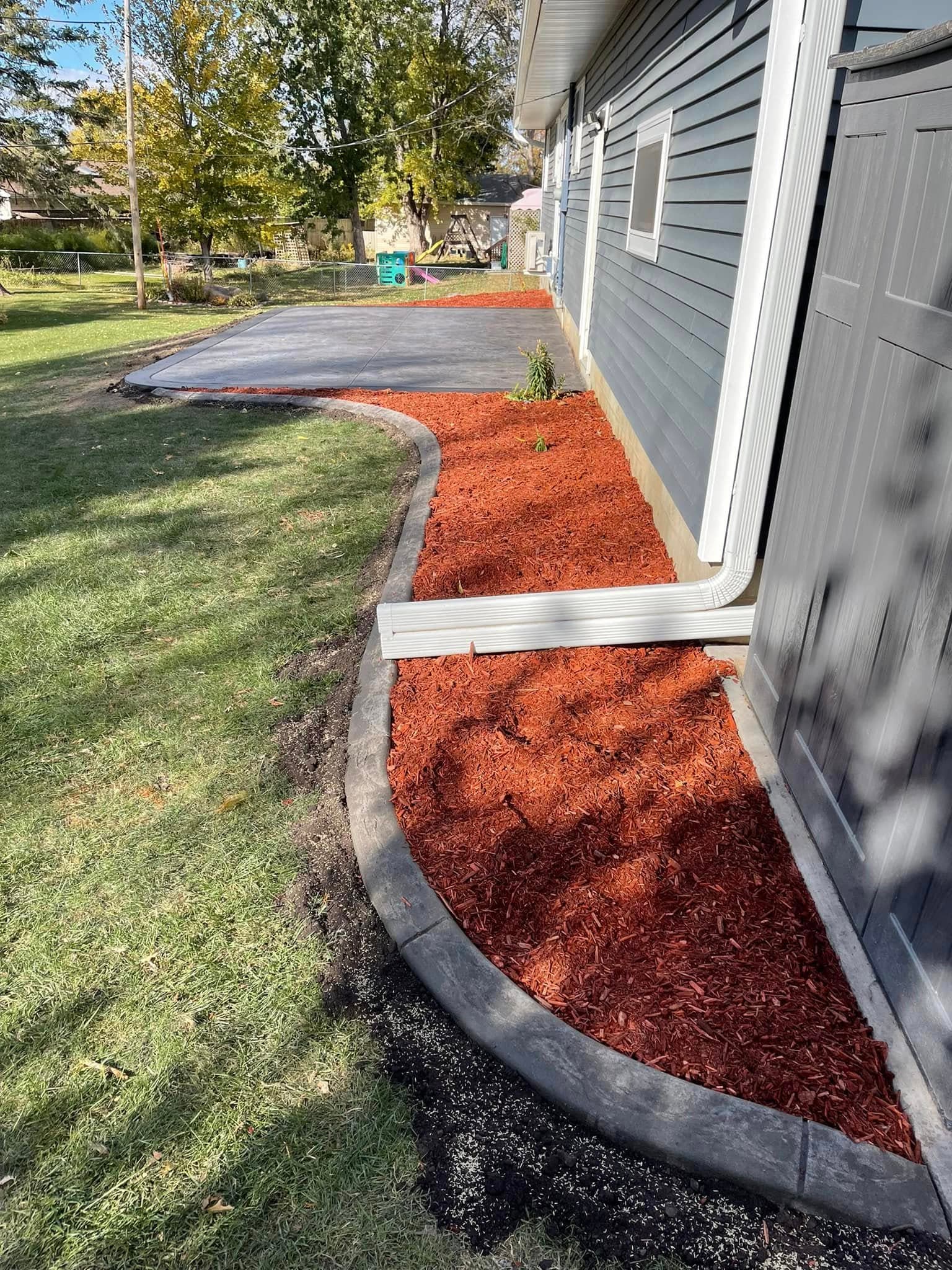 Decorative curbing with fresh mulch installation in Owatonna, Minnesota